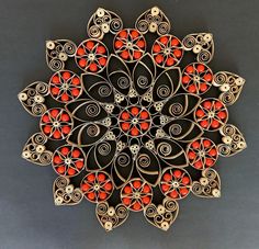 an intricately designed brooch with red beads