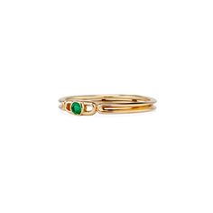 a gold ring with two green stones on the top and bottom, set in 18k yellow gold