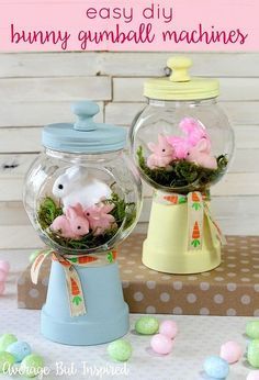 two glass jars filled with fake animals and moss