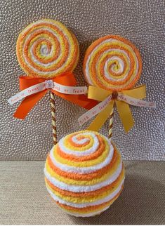 two lollipops are sitting on top of each other with ribbons around them