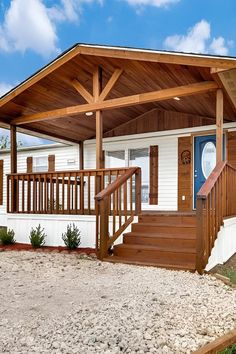 a small white house with wood trim and stairs