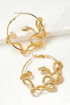 These spectacular earrings feature slitherin' serpents winding 'round a gold or silver hoop. The quintessential addition to any retro-chic look!size: 2.0" Nickel-free Metal Hoop Earrings For Party, Metal Hoop Earrings For Parties, Snake Shape Earrings For Party, Gold Snake-shaped Jewelry With Pierced Ears, Gold Snake-shaped Earrings With Pierced Ears, Gold Snake Jewelry For Pierced Ears, Gold Snake-shaped Jewelry For Party, Gold Snake-shaped Party Jewelry, Brass Hoop Earrings For Party