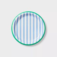 a blue and white striped paper plate with green trim on the rim, against a white background