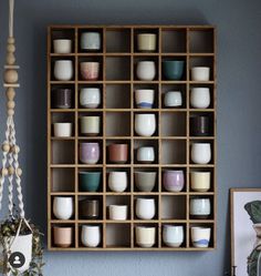 a wooden shelf filled with lots of cups