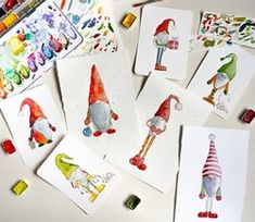 several cards with watercolors on them sitting next to some markers and pencils