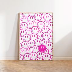 a pink and white poster with smiley faces on it in front of a wooden floor