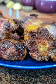 a blue plate topped with meat covered in sauce