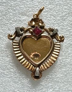 Beautiful Victorian open face heart shaped locket is 18k gold set with a pink tourmaline. The clear cover is missing and can be replaced by jeweler.  It has hallmarks but it has also been tested. It measures 1 7/9" (with bale) x 1 3/8".  It weighs 4.3 grams. Heart Shaped Locket, Open Face, Heart Locket, Gold Set, Pink Tourmaline, Pendant Necklaces, Locket, Tourmaline, Jewelry Necklace Pendant