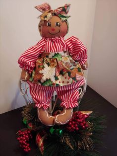 a teddy bear dressed in red and white striped pajamas sitting on top of christmas decorations