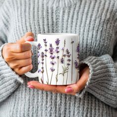 a woman holding a coffee mug with lavender flowers on it