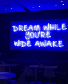 a neon sign that reads, dream while you're wide awake on the wall