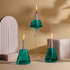 three blue vases with candles in them sitting on a table next to a radiator