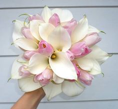 a person holding a bouquet of white and pink flowers