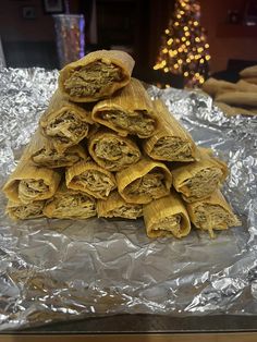 a pile of food sitting on top of aluminum foil covered in tinfoil next to a christmas tree