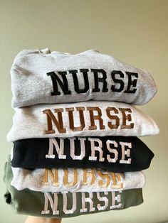 Embroidered NURSE Sweatshirt, Nurse Crewneck, Sweater, RN Sweatshirt, Graduate Nurse, Nursing, Registered Nurse Sweatshirt, Nurse Apparel ITEM DESCRIPTION: This Embroidered NURSE Crewneck Sweater is a great way to add a special touch to your wardrobe. With its comfortable fit, you'll stay warm and stylish. Its quality embroidery adds a professional look and the variety of colors provides plenty of options for styling. -Embroidered Logo: 'NURSE'  -LOGO Size: Approximately 6.5in (width) x 1.75 in (height)  -For Sizes XL & Up, the font spacing/sizing may differ slightly as show in photos to adjust to size of sweater. -Embroidery Color: variety -Sweater/Sweatshirt Color: variety   -50% COTTON | 50% POLYESTER FLEECE | SWEATER | SWEATSHIRT  -There will be a embroidery backing on the inside of ga Crew Neck Top With Embroidered Text For College, Crew Neck T-shirt With Letter Embroidery For College, Crew T-shirt With Letter Embroidery For College, College Crew T-shirt With Letter Embroidery, College Crew T-shirt With Embroidered Text, College T-shirt With Letter Embroidery, Nurse Sweatshirt Ideas, Fall Nursing Sweatshirt With Crew Neck, Nursing School Sweat Shirts