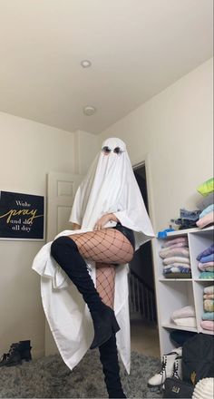 a woman dressed as a ghost is posing for the camera in her room with stockings and boots