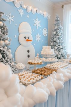 a snowman themed dessert table with cupcakes, cookies and marshmallows