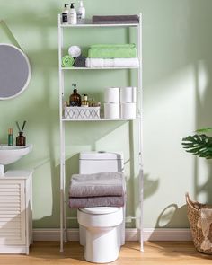 a white toilet sitting next to a shelf filled with towels and other bathroom items on top of it