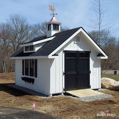 a small white building with a black roof