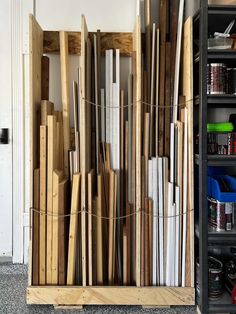 a bunch of wooden boards are stacked up in a storage area next to a door