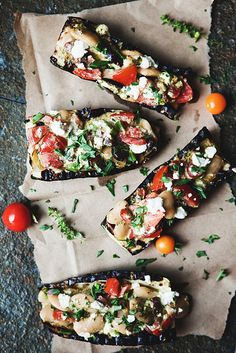 grilled eggplant with tomatoes, feta cheese and parsley on parchment paper