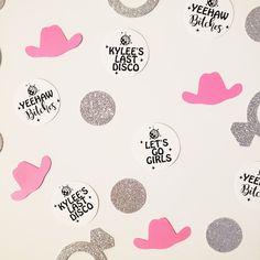 some pink and silver glittered stickers are on a white surface with black dots