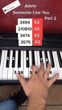 someone is playing the piano with their hand on it's keys and numbers below