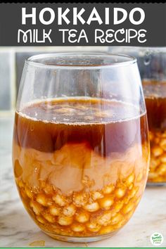 two glasses filled with liquid sitting on top of a table