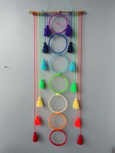 a multicolored wall hanging with several circular objects and tassels on it