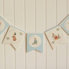 a blue and white bunting banner with peter rabbit images