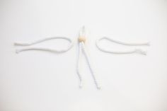 two white ropes tied together on a white surface