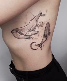 a woman's stomach with a whale and moon tattoo on her side ribcage