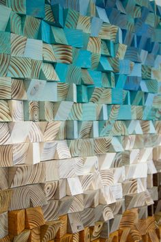 wood pieces are arranged in the shape of an abstract wall hanging on a white wall