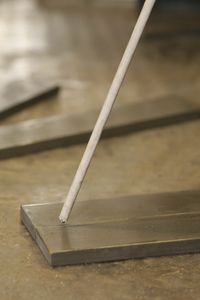 a white toothbrush sitting on top of a wooden table next to a metal object