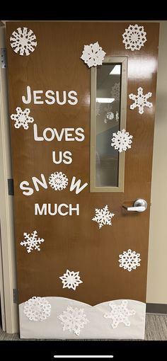 a door decorated with snowflakes and the words jesus loves us, snow much