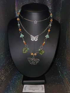 Introducing my stunning Forest Moth Necklace, a unique and remarkable piece of jewelry that will leave you in awe. This necklace is crafted with the utmost care and attention to detail, featuring a mesmerizing combination of green, orange colors with delicate leaves that symbolize nature's beauty. The centerpiece of this necklace is the exquisite moth pendant which exudes confidence and creativity. The green aventurine and protective carnelian stones surrounding it offer a sense of tranquility, Goblincore Crafts Necklaces, Green Long Spiritual Necklace, Green Spiritual Long Necklace, Unique Multicolor Jeweled Necklaces, Bohemian Multicolor Clavicle Chain Necklace, Spiritual Long Green Necklace, Whimsical Green Dangle Jewelry, Green Bohemian Jewelry With Clavicle Chain, Bohemian Green Clavicle Chain Jewelry