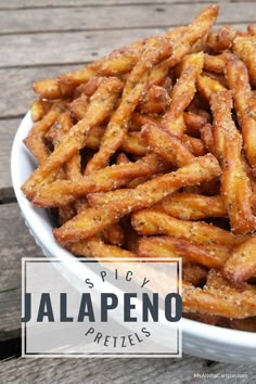 a white bowl filled with cheesy jalapeno pretzels on top of a wooden table