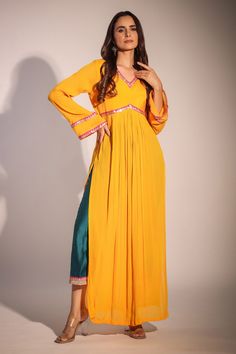 Mango yellow wrinkle crepe kurta with pleated details, bell sleeves, sequin work and V neck. Paired with contrast chanderi straight pant.
Component: 2
Pattern: Embroidered Applique Work
Type Of Work: Sequin Work
Neckline: V Neck
Sleeve Type: Bell Sleeves
Fabric: Kurta: Wrinkle Crepe, Lining: Shantoon, Pant: Chanderi, Lining: Mulmul
Color: Yellow
Other Details: 
Side slits
Cut work back
Back tasselled tie-up
Embroidered border on pants
Attached lining
Occasion: Sangeet,Mehendi and Haldi - Aza Fas Gown Anarkali, Western Party Wear, Alia Cut, Mango Yellow, Applique Work, Embroidered Border, Party Kleidung, Silk Tunic, Anarkali Suit