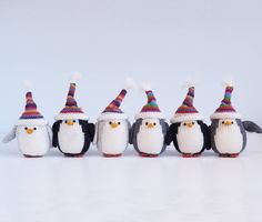 a group of penguins wearing knitted hats