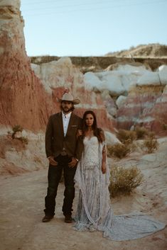 a man and woman standing next to each other in the desert