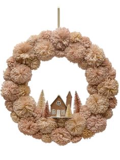 a wreath with a house and trees hanging from the front, on a white background