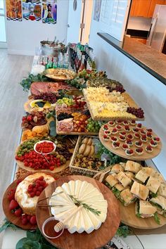 a long table filled with lots of different types of cheeses and other food items