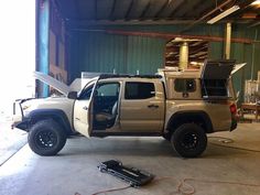 the truck is parked in the garage with its doors open