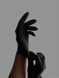 a person wearing black gloves holding their hands up