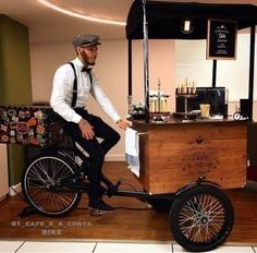 a man is sitting on top of a bike in front of a coffee shop counter