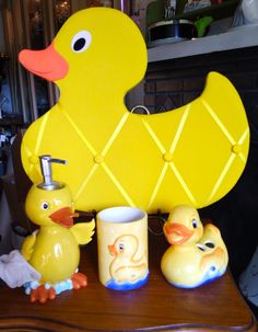 a wooden table topped with two yellow ducks and a cup on top of each other