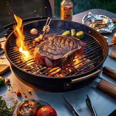 a steak is cooking on the grill with tongs and other food items around it