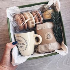 a person holding a coffee mug and some cookies