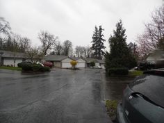 an empty street with houses and trees in the background