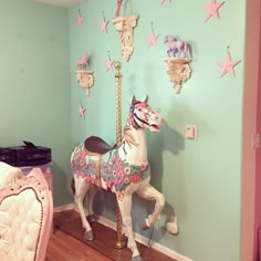 a toy horse sitting on top of a wooden floor next to a wall mounted clock